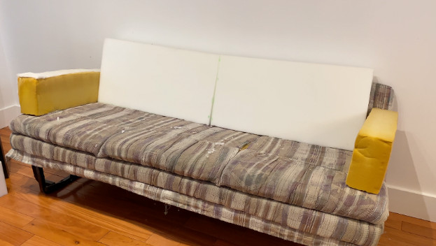 appuie-bras du divan-lit avec les vieilles mousses